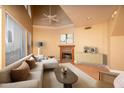 Bright living room boasts a fireplace, a ceiling fan, and multiple windows bringing in natural light at 4927 E Hazel Dr # 2, Phoenix, AZ 85044