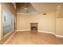 Bright living room featuring a cozy fireplace, soaring ceilings, large windows, and gleaming hardwood floors at 4927 E Hazel Dr # 2, Phoenix, AZ 85044