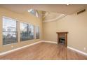 Bright living room featuring a cozy fireplace, soaring ceilings, large windows, and gleaming hardwood floors at 4927 E Hazel Dr # 2, Phoenix, AZ 85044