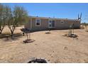 Wide shot of the back side of a house with minimal desert landscaping at 52150 W Cardinal S Rd, Maricopa, AZ 85139