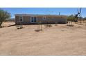 Wide shot of a single-story home with a back door and desert landscaping at 52150 W Cardinal S Rd, Maricopa, AZ 85139