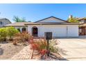 Charming single-story home with a well-manicured lawn and a classic white brick facade at 5325 W Desert Hills Dr, Glendale, AZ 85304