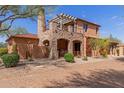 Stunning two-story home featuring stone accents, a pergola-covered balcony, and a terracotta tile roof at 7600 E Golden Eagle Cir, Gold Canyon, AZ 85118