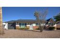Charming single-story home featuring a well-maintained front yard with desert landscaping and a gray painted garage door at 8408 E Lewis Ave, Scottsdale, AZ 85257