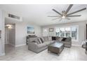 Living room features neutral decor, large sectional sofa, fan, and window shutters at 8408 E Lewis Ave, Scottsdale, AZ 85257