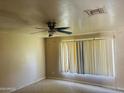 Bedroom featuring a ceiling fan, large window with blinds, and textured walls, offering natural light at , Tempe, AZ 85282