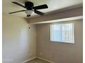 Cozy bedroom with a ceiling fan, a window providing natural light and patterned carpet at , Tempe, AZ 85282