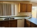 Well-lit kitchen includes a stainless steel sink, neutral countertops, and light wood cabinets, perfect for cooking at , Tempe, AZ 85282