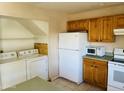 Cozy kitchen includes a laundry area, light wood cabinets, and white appliances for convenient living at , Tempe, AZ 85282