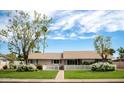 Charming single-story home with a lush green lawn, white picket fence, and mature flowering trees at 2017 W Edgemont Ave, Phoenix, AZ 85009