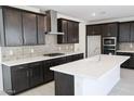 Spacious kitchen featuring dark wood cabinets, stainless steel appliances, and a large kitchen island with seating at 2442 W Rowel Rd, Phoenix, AZ 85085