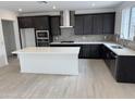 Modern kitchen features stainless steel appliances, gray backsplash, a center island, and dark cabinets at 2470 W Rowel Rd, Phoenix, AZ 85085