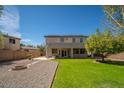 Backyard featuring a gravel area, a cozy fire pit, and a lush green lawn and various trees at 3547 N 145Th Ave, Goodyear, AZ 85395