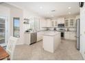 Modern kitchen with white cabinets, granite countertops, stainless steel appliances, and an island at 3547 N 145Th Ave, Goodyear, AZ 85395