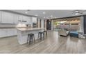 Modern kitchen with white cabinets, granite countertops, and stainless steel appliances open to the living area at 3938 E Ficus Way, Gilbert, AZ 85298