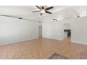 Spacious living room featuring neutral walls, ceramic tile floors, arched doorways, and a ceiling fan at 1165 E Avenida Kino --, Casa Grande, AZ 85122