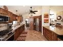 Spacious kitchen with stainless steel appliances, wood cabinets, granite countertops, and tile floors at 13390 N 95Th Way, Scottsdale, AZ 85260