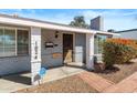 Inviting front porch with brick accents and a wood front door with updated fixtures at 1624 W Thomas Rd, Phoenix, AZ 85015