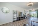 Bright living room showcasing stylish hardwood floors, tasteful decor, and a view into the dining area and outdoor patio at 17241 N 16Th Dr # 1, Phoenix, AZ 85023