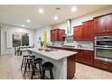 Modern kitchen with granite countertops, dark wood cabinets, stainless steel appliances, and a center island at 1874 E Crescent Way, Chandler, AZ 85249