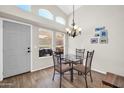 Bright dining area features modern chandelier, table with chairs, high ceilings, and backyard view at 19815 N 49Th Ave, Glendale, AZ 85308