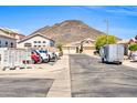 Community street view showcases a mix of single-Gathering homes, desert landscaping, and a backdrop of scenic mountains at 19815 N 49Th Ave, Glendale, AZ 85308