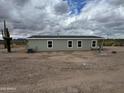 Well-maintained single-story home surrounded by desert landscape with low-maintenance yard at 25958 W Muirfield Dr, Morristown, AZ 85342