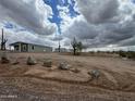Spacious single-story home situated on a large lot with rocks in desert landscaping at 25958 W Muirfield Dr, Morristown, AZ 85342