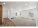 Bright living room featuring plush carpeting, fresh paint, and natural light at 25958 W Muirfield Dr, Morristown, AZ 85342