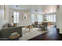 Bright living room featuring wood floors, lots of natural light, and modern furniture with an adjacent dining area at 2982 E Boston St, Gilbert, AZ 85295