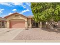 Attractive single-story home featuring a two-car garage, a low-maintenance gravel yard, and a mature shade tree at 3668 E Cody Ave, Gilbert, AZ 85234