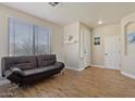 Cozy living room featuring wood floors, neutral paint, and a black futon at 384 N Scott Dr, Chandler, AZ 85225