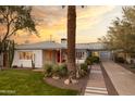 Inviting exterior showcasing a well-manicured lawn, desert landscaping, and a charming white brick home at 536 W Windsor Ave, Phoenix, AZ 85003
