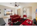 Bright living area with a red leather sofa and contemporary decor with a view to the entry at 8661 E Ivy St, Mesa, AZ 85207