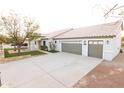 Spacious three-car garage with a concrete driveway, complemented by manicured landscaping at 9732 N Penworth Dr, Casa Grande, AZ 85122
