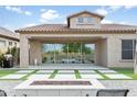 Backyard featuring artificial grass, a fire pit, patio area, and sliding glass doors to the home's interior at 1816 N Bernard Cir, Mesa, AZ 85207