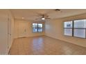 Bright living room featuring tile floors, a ceiling fan, and large windows providing ample natural light at 803 W Burkhalter Dr, San Tan Valley, AZ 85143