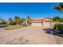 Beige home with a spacious three car garage, desert landscaping, and a long paver driveway at 11224 E Carol Ave, Scottsdale, AZ 85259