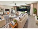 Bright living room with modern furnishings, stylish decor, and sliding door to the backyard pool at 11663 W Luxton Ln, Avondale, AZ 85323