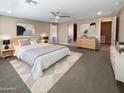 Spacious main bedroom with a ceiling fan, soft carpet, and neutral decor at 11663 W Luxton Ln, Avondale, AZ 85323