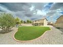 Large backyard showcasing well-kept lawn, patio area, and mature trees at 15454 W Evans Dr, Surprise, AZ 85379