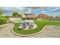Expansive backyard with manicured lawn, patio, and lounge area, great for entertaining at 15454 W Evans Dr, Surprise, AZ 85379