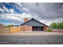 Modern single-story home with attached carport, brick accents, and unique architectural design at 1556 E Dover Cir, Mesa, AZ 85203