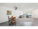 Spacious living room with white walls, ceiling fans, a breakfast nook, and a combination of carpet and tile flooring at 17885 N 99Th Dr, Sun City, AZ 85373
