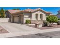 View of the attached three-car garage and landscaped side yard of the single-story home at 1834 E Scorpio Pl, Chandler, AZ 85249