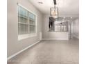 Open-concept living space features lots of natural light, tile floors and an attractive chandelier at 19726 W Woodlands Ave, Buckeye, AZ 85326