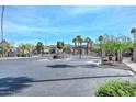 Gated community entrance with desert landscaping and palm trees at 2116 E Beautiful Ln, Phoenix, AZ 85042