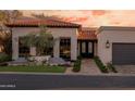 Attractive single-story home with a decorative front door, terracotta tile roof, and lush landscaping at 2421 E Montebello Ave, Phoenix, AZ 85016