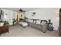 Inviting living room with a large comfortable sofa, carpet, and ceiling fan at 2424 E Aster Dr, Phoenix, AZ 85032