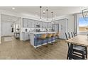Kitchen island with barstool seating, modern stainless appliances and gray cabinetry at 24540 N 144Th Ave, Surprise, AZ 85387